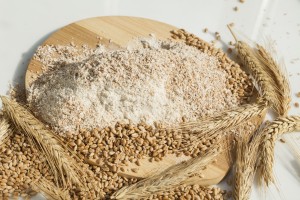 wheat flour of a rough grinding. Grain and spikelets on table